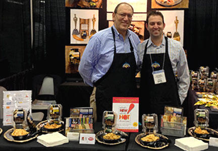 Seth and his father Barry Novick stand behind their booth at the Fancy Food Show.